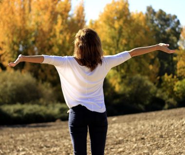 Woman staring the sky and opening her arms