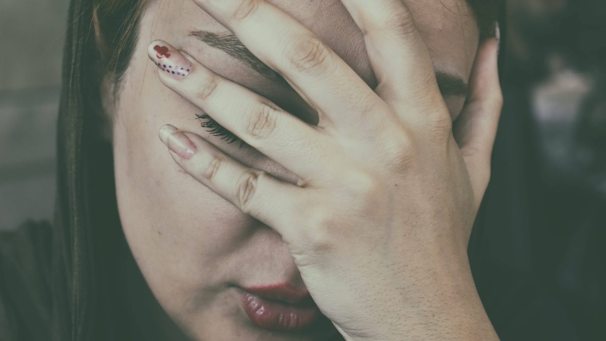 Woman with a headache touching her face