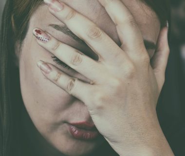 Woman with a headache touching her face